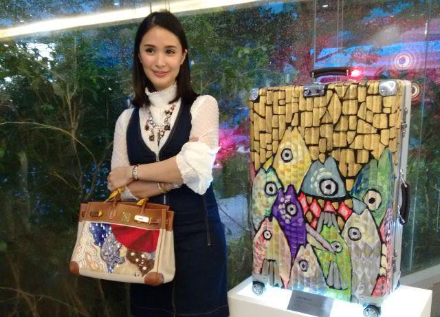 Heart Evangelista, the artist, paints branded bags