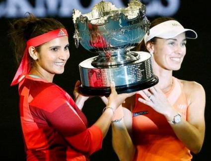 Switzerland's Martina Hingis (R) and India's Sania Mirza pose with the trophy after winning their doubles final match at the Australian Open tennis tournament at Melbourne Park, Australia REUTERS/