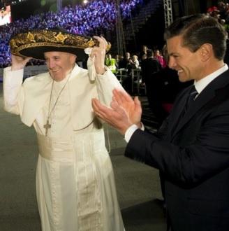 Pope Francis tries on a Mariachi hat as Mexico's President Enrique Pena Nieto applauds after his arrival in Mexico City. REUTERS