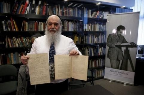 Roni Gross, curator of the Hebrew University's Albert Einstein Archive, displays original documents related to Albert Einstein's hypothesis of the existence of gravitational waves during a news conference in Jerusalem. REUTERS