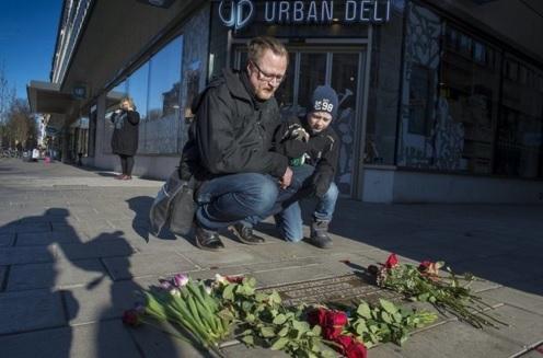 A man and his son visit the site where former prime minister Palme was assasinated, on the 30th anniversary of his assassination, at Sveavagen in central Stockholm. REUTERS