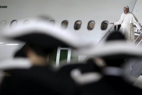 Pope Francis walks down the staircase as a Mariachi band awaits him after his arrival in Mexico City. REUTERS