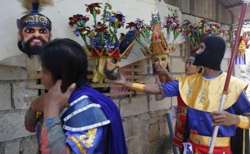 Members of the Mazon family get their masks on the second day of Holy Week celebrations in Mogpog, Marinduque. REUTERS