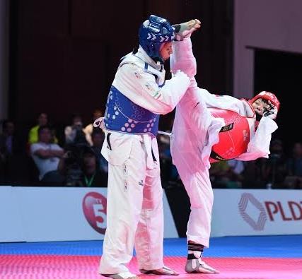 Kirstie Elaine Alora of the Philippines connects with a front kick to Iran's Akram Khodobandeh. Photo by Martin San Diego