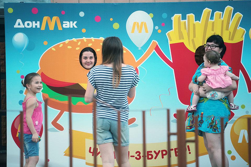 People take pictures with a 'DonMac' fast food restaurant's banner in Donetsk, eastern Ukraine in this photo taken on June 8, 2016. Donetsk, a rebel stronghold, two other former 'McDonald's' opened their doors under the named 'DonMak' in early July. Similar to the one in Lugansk, they are located in the former premises of the US chain and offer the same kind of products. Their opening was a sensation in the de facto capital of the pro-Russian separatists -- despite the rebel leadership frequently slamming the US as an enemy while emphasizing cultural ties with Russia. AFP/Aleksey Filippov 