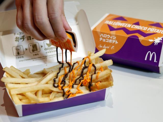 An employee of McDonald's Japan puts pumpkin and choco sauce on a McFry Potato to demonstrate their company's 'Halloween Choco Fries - Pumpkin & Choco Sauce' in Tokyo, Japan, September 29, 2016. Photo: REUTERS/Toru Hanai 