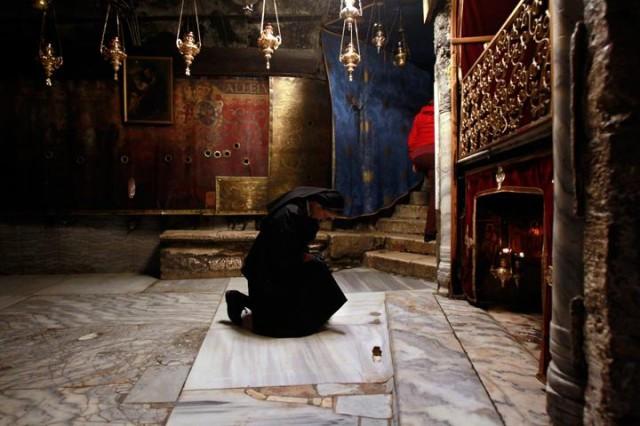 A nun prays at the Grotto in the Church of the Nativity, believed to be the birthplace of Jesus Christ, in the West Bank city of Bethlehem on December 20, 2016. Photo: MUSA AL SHAER / AFP.