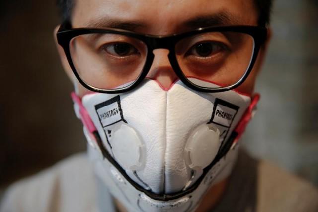 Designer Wang Zhijun poses for pictures wearing one of the face masks he made using sneakers, in Beijing, China December 21, 2016. Photo: REUTERS/Damir Sagolj.