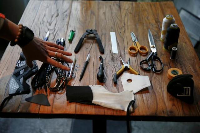 Designer Wang Zhijun demonstrates how he makes face masks using sneakers, in Beijing, China December 21, 2016. Photo: REUTERS/Damir Sagolj.