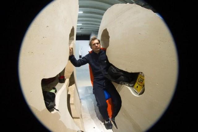 This picture taken with a fisheye lens shows French artist Abraham Poincheval performing "Pierre" (Stone), at the Palais de Tokyo on February 22, 2017 in Paris. AFP PHOTO