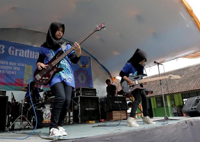 Widi Rahmawati (L) and Firdda Kurnia, members of the metal Hijab band Voice of Baceprot, perform during a school's farewell event in Garut, Indonesia, May 15, 2017. Picture taken May 15, 2017. REUTERS/Yuddy Cahya.