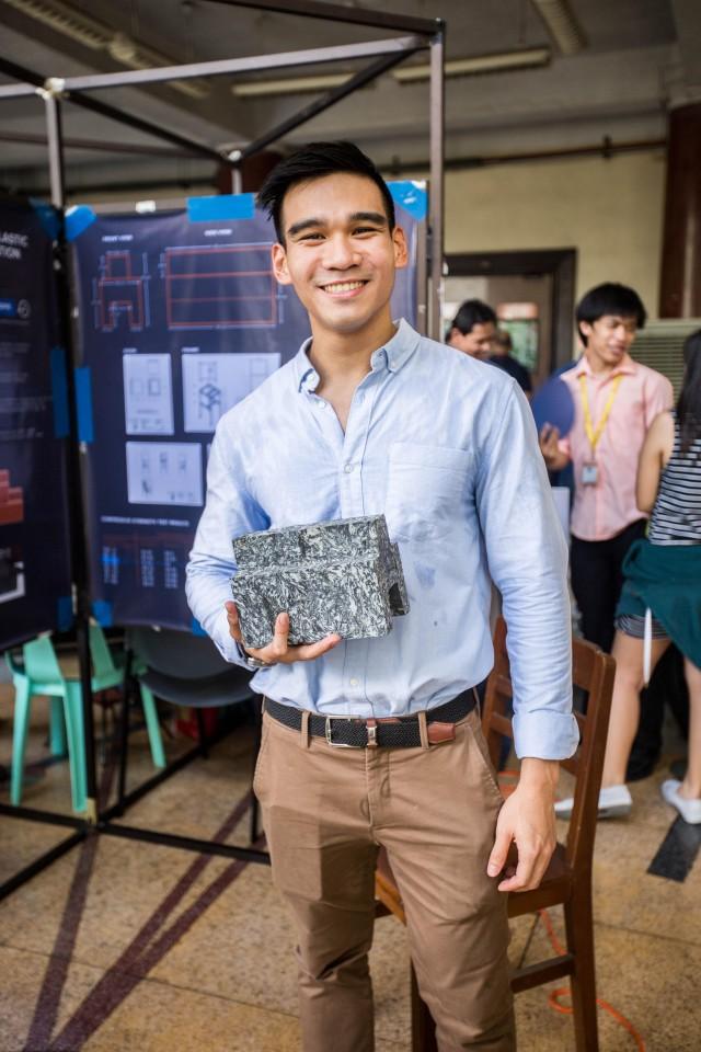 Justin Christian Padilla from the Institute of Civil Engineering showing off a plastic brick prototype for construction (Undergraduate Project Competition exhibit, College of Engineering, June 2, 2017)