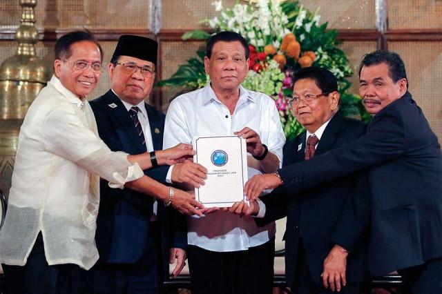 President Rodrigo Duterte receives a draft of the newly proposed Bangsamoro Basic Law (BBL) in a turnover ceremony in MalacaÃ±ang on Monday, July 17, 2017. Joining the President are (from left) Presidential Adviser on the Peace Process Jesus Dureza, Moro Islamic Liberation Front Chairman Murad Ebrahim, Bangsamoro Transition Commission Chair Ghazali Jaafar, and MILF Peace Implementing Panel Chair Mohagher Iqbal. Rolando Mailo/PPD 