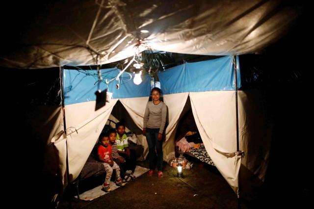 Veronica Dircio, 34, with her sons in front of a tent in a neighbor's backyard after an earthquake in San Juan Pilcaya, Mexico, September 28, 2017.REUTERS/Edgard Garrido 