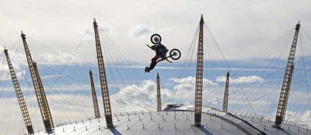 Action sports performer Travis Pastrana somersaults on his motorbike as he jumps between two barges on the River Thames with the O2 Arena sports venue seen behind, in London, Britain, October 5, 2017. REUTERS/Toby Melville 