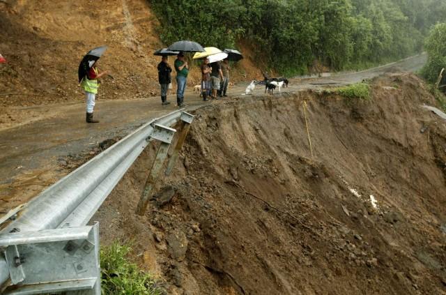 Residents look at a road partially collapsed by heavy rains brought about by Tropical Storm Nate that affects the country in El Llano de Alajuelita, Costa Rica October 5, 2017. REUTERS/Juan Carlos Ulate