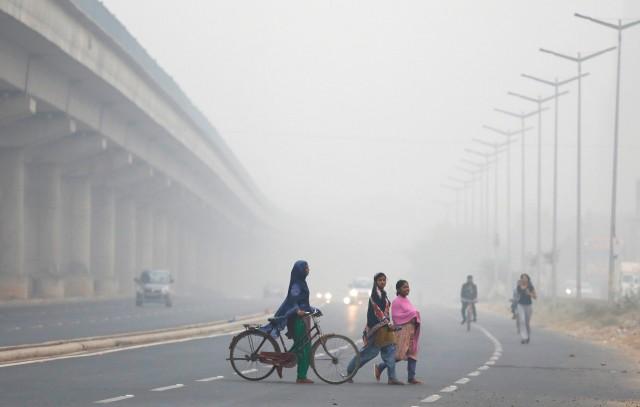 People cross a road on a smoggy morning in New Delhi, India, November 8, 2017. Reuters