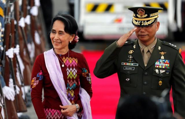 Myanmar State Counsellor Aung San Suu Kyi walks with a Filipino military officer upon her arrival to attend the ASEAN Summit and related meetings, in Clark, Pampanga. <b>Reuters</b>
