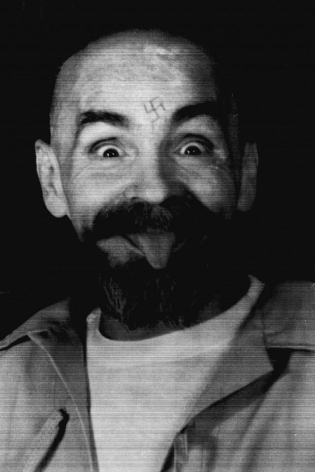 Charles Manson clowns around as he is led to his cell upon the conclusion of his exclusive interview with Reuters August 25, 1989. REUTERS/File Photo