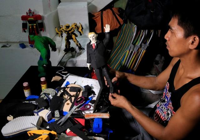 Elmer Padilla, 30, who is famous for creating action figures out of discarded slippers, puts the finishing touches on a figure of U.S. President Donald Trump (C) at his workshop in metro Manila, Philippines, November 8, 2017. REUTERS/Romeo Ranoco