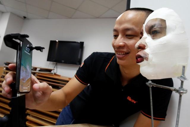 Ngo Tuan Anh, Vice President of Bkav, a Vietnamese cybersecurity firm, demonstrates iPhone X Apple's face recognition ID software with a 3D mask at his office in Hanoi, Vietnam November 14, 2017. REUTERS/Kham