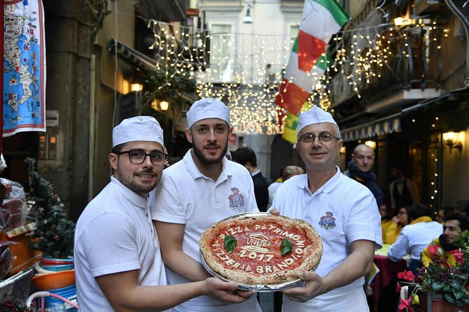 Neapolitan pizza makers pose with a pizza to celebrate the Unesco decision to make the art of Neapolitan 