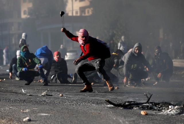 A Palestinian protester uses a sling to hurl stones towards Israeli troops during clashes as Palestinians call for a "day of rage" in response to U.S. President Donald Trump's recognition of Jerusalem as Israel's capital, near the Jewish settlement of Beit El, near the West Bank city of Ramallah December 8, 2017. REUTERS/Mohamad Torokman