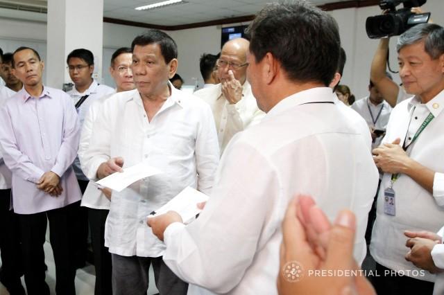 President Rodrigo Roa Duterte turns over a check worth over P100M to Veterans Memorial Medical Center (VMMC) Director Dominador Chiong Jr. during the President's visit to the hemodialysis patients at the VMMC in Quezon City on December 20, 2017. The President further committed to provide P50-million to the medical facility every month. KING RODRIGUEZ/PRESIDENTIAL PHOTO