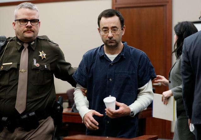 Dr. Larry Nassar, a former team USA Gymnastics doctor who pleaded guilty in November 2017 to sexual assault charges, is escorted by a court officer during his sentencing hearing in Lansing, Michigan, U.S., January 16, 2018. REUTERS/Brendan McDermid