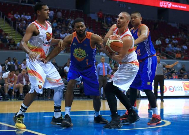 Mo Tautuaa of TNT Ka Tropa and Doug Kramer of Phoenix Fuel Masters battle for the ball possesion during the 43rd PBA Philippine Cup in MOA Arena on Wednesday. PHOTO BY KC Cruz