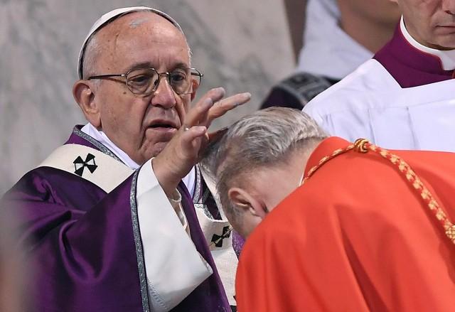 Pope Francis puts ashes on the head of a cardinal during the Ash Wednesday mass at Santa Sabina Basilica in Rome, Italy, February 14, 2018. REUTERS/Alberto Lingria