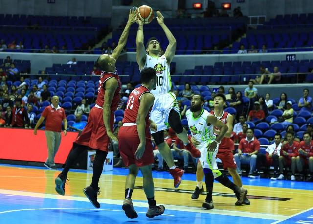 Sean Anthony of GlobalPort goes for a shot against two defenders of KIA during their game in the 43rd PBA Philippine Cup in Araneta Coliseum on Wednesday. PHOTO BY KC Cruz