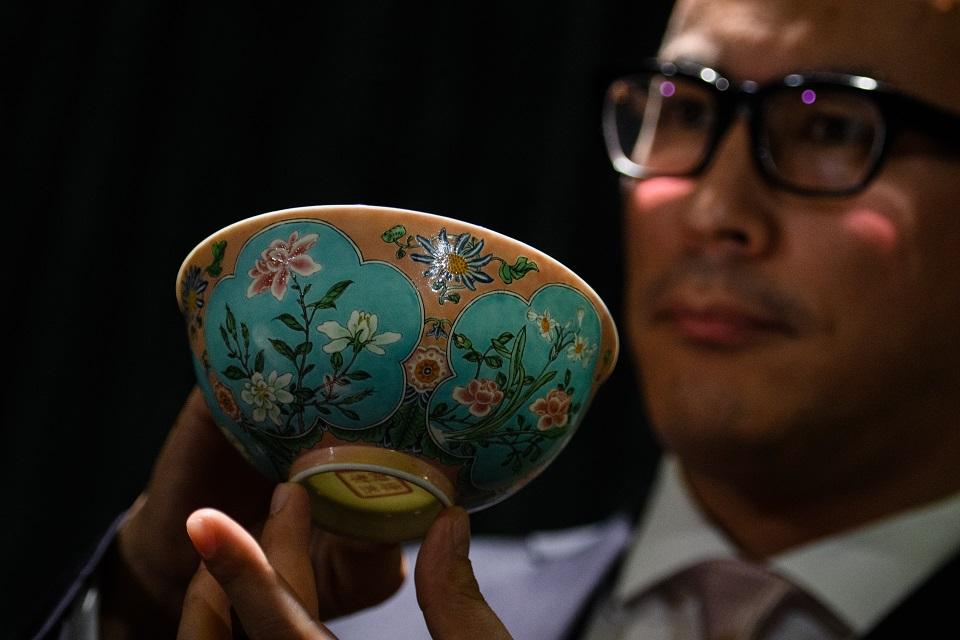 Sotheby's Asia deputy chairman Nicolas Chow holds an extremely rare Qing Dynasty bowl&acirc;one of only three known to exist&acirc;at the auction house in Hong Kong on March 1, 2018, before its upcoming sale on April 3. Anthony Wallace/AFP
