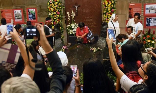 Catholic faithful pray around the tomb of blessed Oscar Arnulfo Romero on the centenary of his birth, in San Salvador on August 15, 2017. Romero, who was assassinated in 1980 and whose defense of the poor divided his nation and the Church, was beatified in 2015. He was killed by gunmen linked to El Salvador's right-wing military government at the time in the midst of a brutal civil war that began in 1979 and ended in 1992. Marvin Recinos/AFP