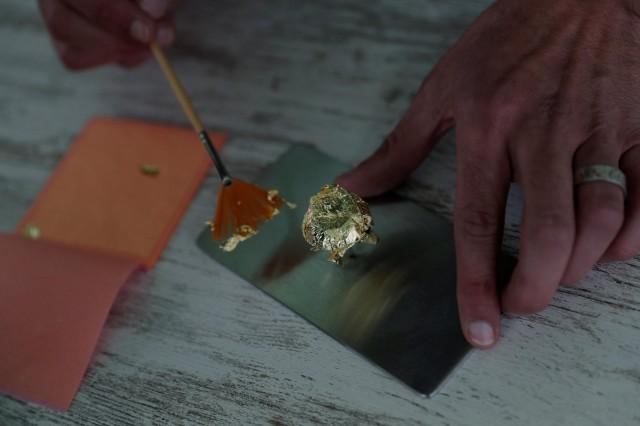 Portuguese chocolatier Daniel Gomes prepares a candy wrapped in pure 23 carat gold during international chocolate fair in Obidos Portugal, March 16, 2018. REUTERS/Rafael Marchante