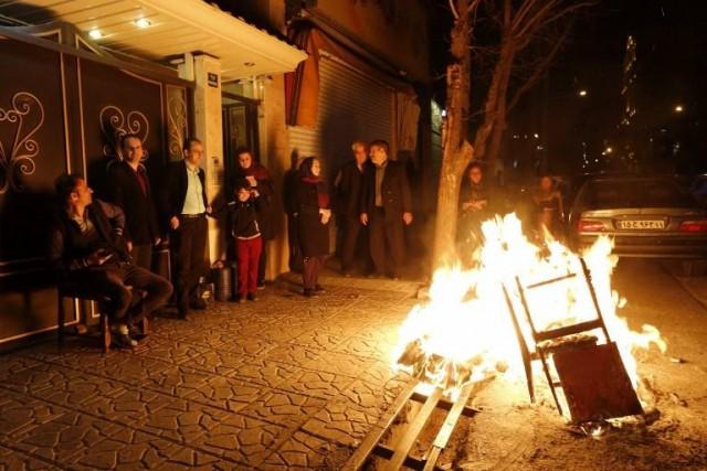 Iranian families light fire outside their houses in Tehran on March 13, 2018 during the Wednesday Fire feast, or Chaharshanbeh Soori, held annually on the last Wednesday eve before the Spring holiday of Noruz. ATTA KENARE / AFP