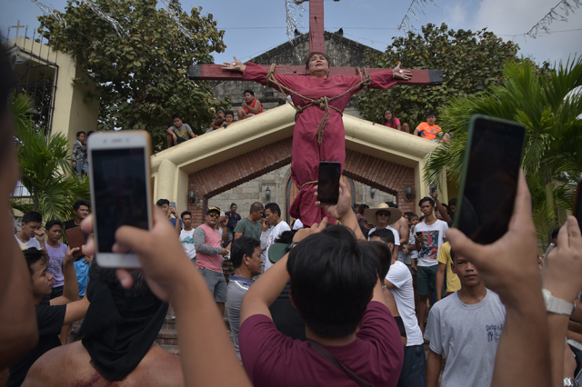Spectators snap photos of Elsie Cunanan crucified in San Vicente Bacolor Pampanga
