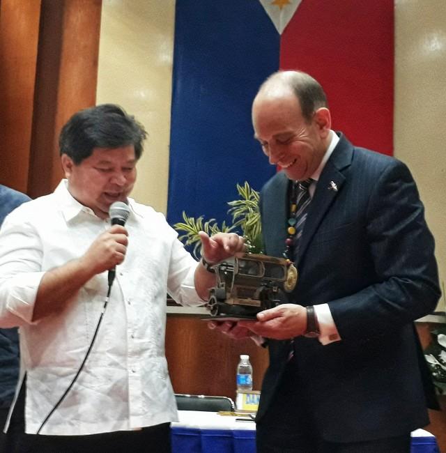 UK Ambasador to the Philippines Daniel Pruce smiles as he receives a mini-replica of the iconic pedicab given to him by Dumaguete City Mayor Felipe Remollo. Photo: Raffy Cabristante