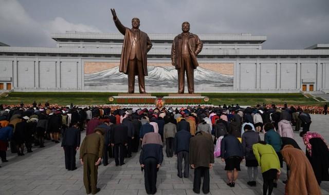 People bow as they pay their respects before the statues of late North Korean leaders Kim Il Sung and Kim Jong Il, at Mansu hill in Pyongyang April 15, 2018. Ed Jones/AFP