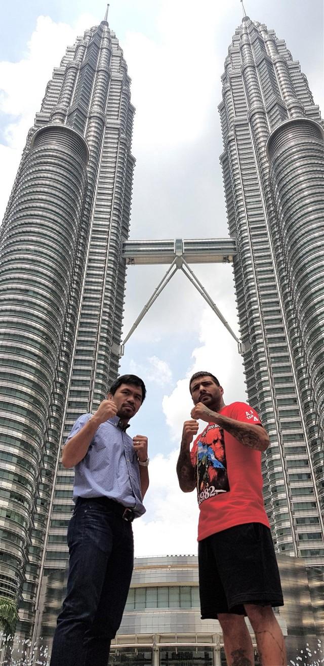 The iconic Petronas Twin Towers in downtown Kuala Lumpur serves as a backdrop to Manny "Pacman" Pacquiao and WBA welterweight champion Lucas Matthysse of Argentina as they pose to promote their bout on July 15 at the Axiata Arena in the Malaysian capital. MP Promotions Media