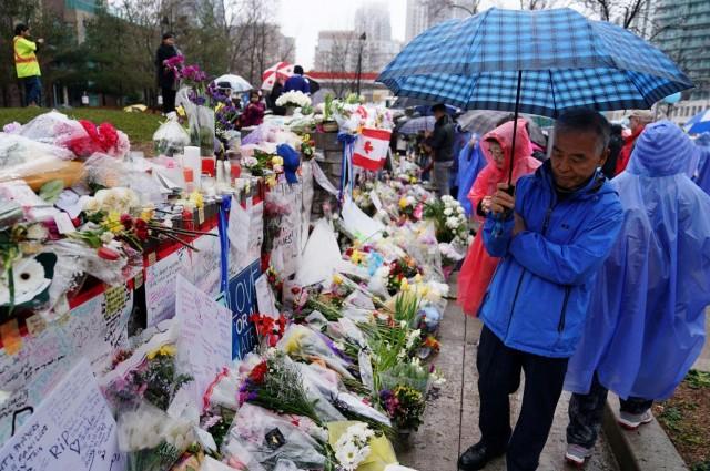 People pay their respects at a makeshift memorial on Yonge Street following a van that attacked multiple people in Toronto, Ontario, Canada, April 25, 2018. REUTERS/Carlo Allegri
