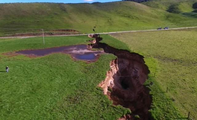 This frame grab from TVNZ video footage taken on May 2, 2018 and released to AFP on May 7 shows a sinkhole that appeared on a dairy farm near Rotorua on New Zealand's North Island. TVNZ/AFP