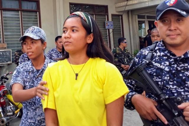 Youth activist Myles Albasin is escorted outside the Bais City Regional Trial Court on May 2, 2018 after pleading "not guilty" to the illegal possession of firearms and explosives charges against her. Photo: Raffy Cabristante