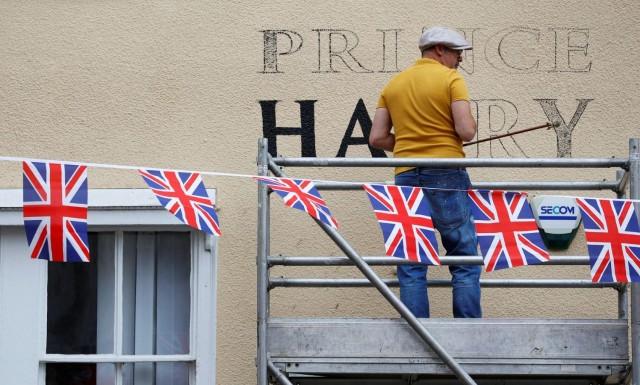 A worker paints the new name on a pub in honor of Prince Harry and Meghan Markle's wedding, in Windsor, Britain, May 16, 2018. REUTERS/Phil Noble