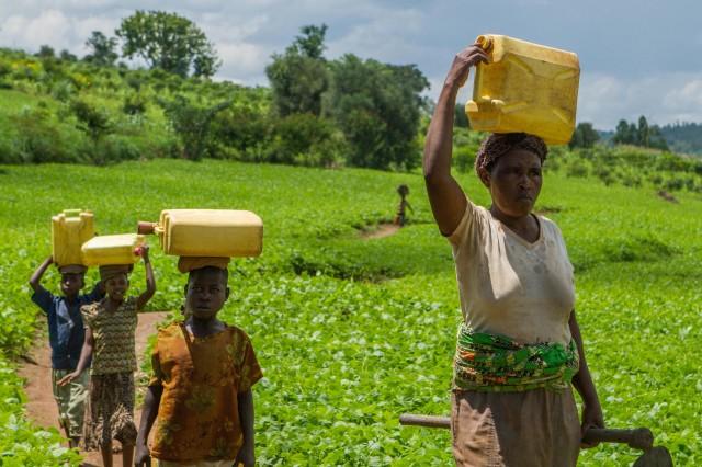 Residents carry water in jerrycans from a project supported by former Global Ambassador for World Vision, Meghan Markle, in Gatsibo district, Rwanda April 27, 2018. Picture taken April 27, 2018. REUTERS/Jean Bizimana