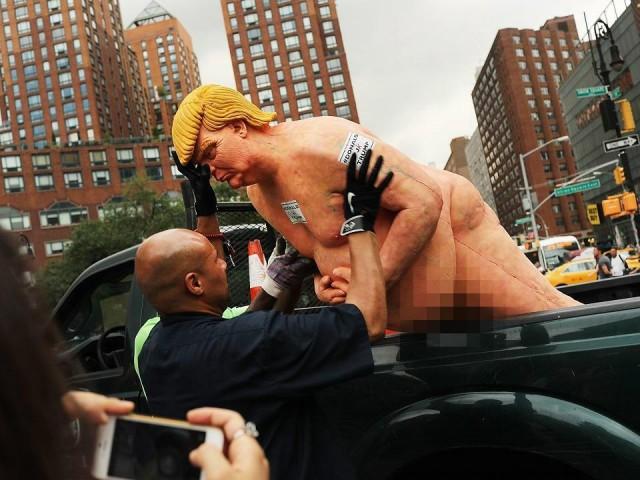 Park authorities haul away a statue of then-presidential candidate Donald Trump in Union Square Park in New York City on August 18, 2016. The illegally placed statue drew hundreds of curious onlookers, who took selfies with the statue, which was signed "Ginger." A published report attributed the work to the anarchist collective INDECLINE, which titled the project "The Emperor Has No Balls." Spencer Platt/Getty Images/AFP