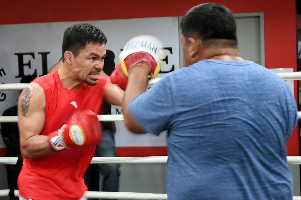 Boxing icon and Senator Manny Pacquiao (left) spars with his childhood friend and long-time assistant trainer Buboy Fernandez during a training session at a gym in Manila on Thursday, May 17, 2018, ahead of his world welterweight boxing championship bout against Argentina's Lucas Matthysse in July. AFP/Ted Aljibe 