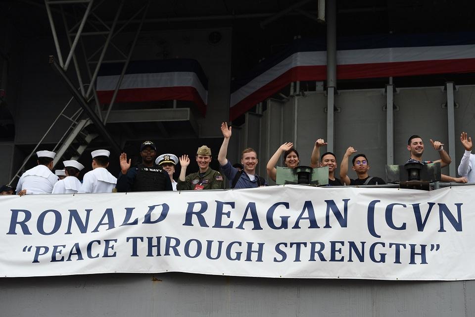 US sailors wave to photographers on board the USS Ronald Reagan. Ted Aljibe/AFP
