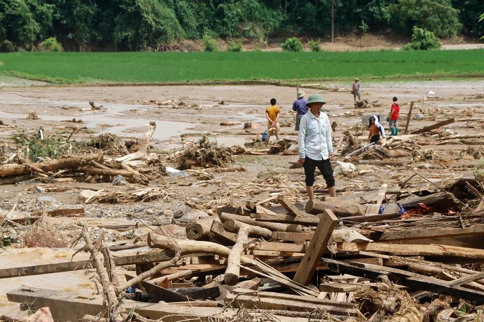 Residents clear debris in a village damaged by flash flooding in Vietnam's Yen Bai province on July 21, 2018. At least 10 people have died after floods spurred by typhoon rains struck central and northern Vietnam, authorities said on July 21. Anh Tuan/AFP