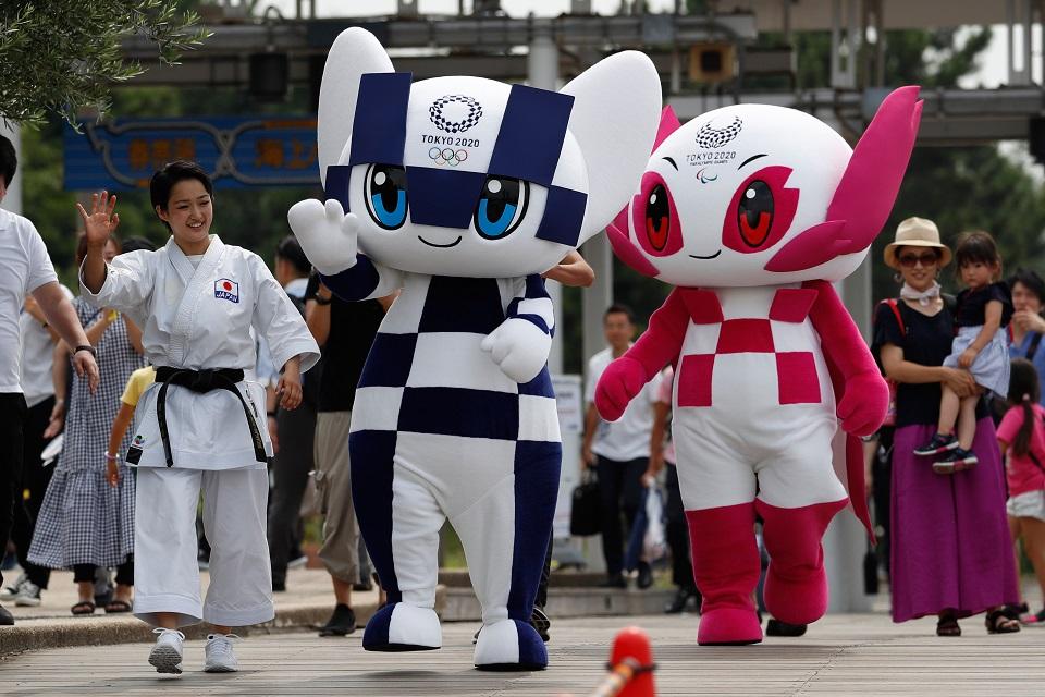 Tokyo 2020 Olympic Games mascot Miraitowa (C) and Paralympic mascot Someity wave with Japanese karateka Kiyo Shimkizu upon their arrival after a parade at Odaiba Marine Park in Tokyo on July 22, 2018. Issei Kato/Pool/ AFP